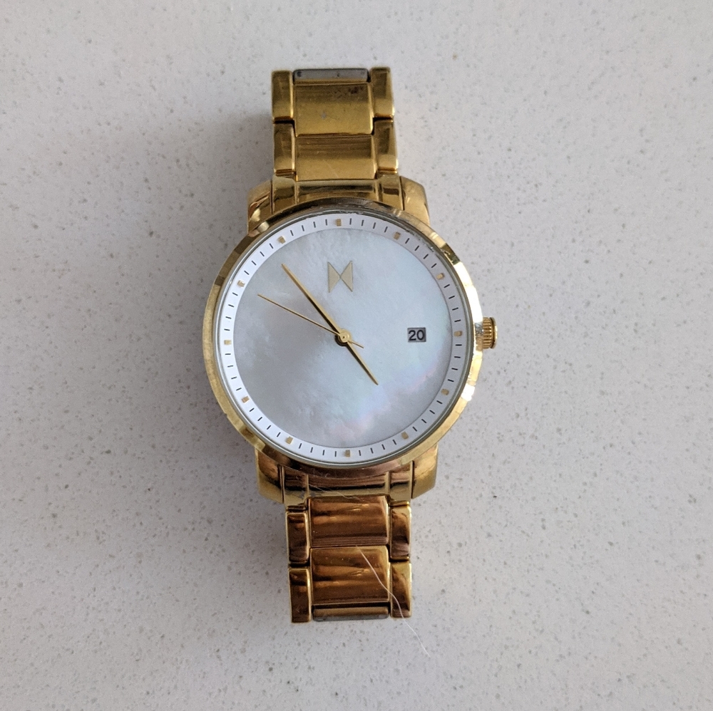 Gold MVMT watch with pearl face